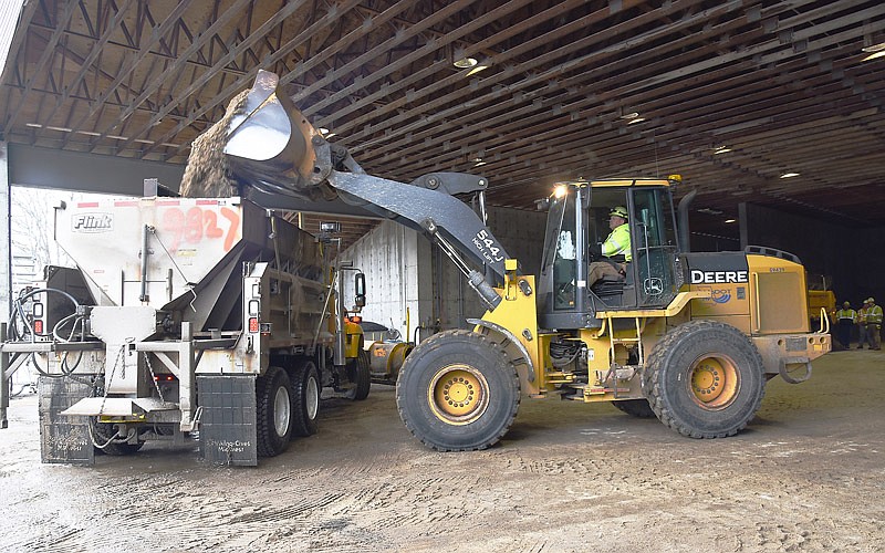 Jeff Buschjost operates a John Deere front-end loader Thursday, Feb. 28, 2019, at MoDOT's Central District Facility in Apache Flats to refill truck beds with sand or salt.
