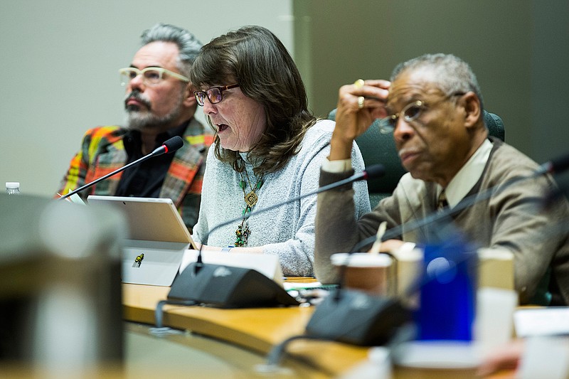 In this Monday, March 4, 2019 photo, Dallas Landmark Commissioner Emily Williams, center, makes a motion during a Dallas Landmark Commission meeting at City Hall in Dallas, to vote to remove the Confederate War Memorial in front of the downtown convention center. Commissioner Donald Payton, at right, listens The commission voted 10-5 to approve the removal of the memorial. (Ashley Landis/The Dallas Morning News via AP)