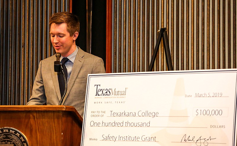 James Hensen, Texas Mutual's manager of safety services for the Dallas region, presents a check for $100,000 to Texarkana College for safety training Tuesday at the college in Texarkana, Texas.