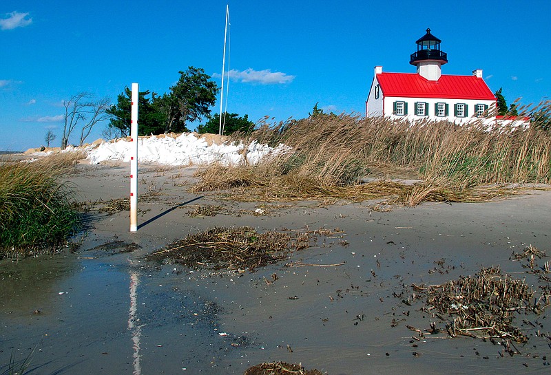 In this Nov. 10, 2018, file photo, water from the Delaware Bay approaches the East Point Lighthouse in Maurice River Township, N.J. Rising seas and erosion are threatening lighthouses around the world, including the East Point Lighthouse. As climate change becomes a hotter topic in American classrooms in 2019, some politicians are pushing back against the scientific consensus that global warming is real and man-made. (AP Photo/Wayne Parry, File)