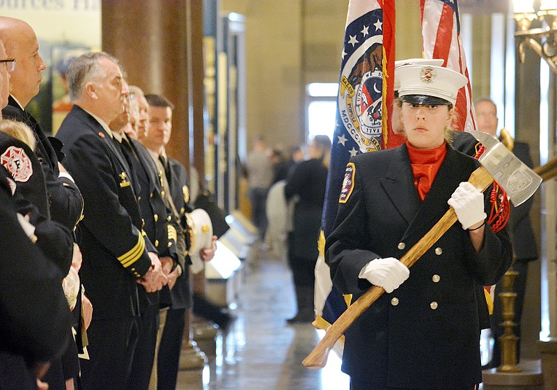 An Honor Guard carries an ax Wednesday after the posting of colors during the opening ceremony of Fire Fighters Day at the Capitol Rotunda. The annual event recognizes firefighters and EMS personnel who go above and beyond in protecting Missourians.