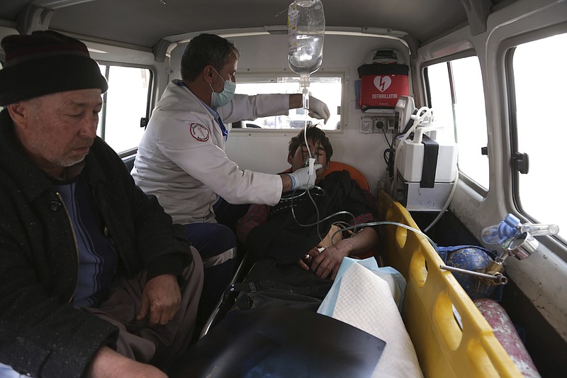 Afghans treat an injured man in an ambulance, in Kabul, Afghanistan, Thursday, March 7, 2019. Afghan officials say several explosions have struck outside a ceremony in Kabul attended by the country's chief executive and the former president, both of whom were unharmed. However, there was conflicting information as to the casualty figures in the immediate aftermath of the attack. (AP Photo/Rahmat Gul)