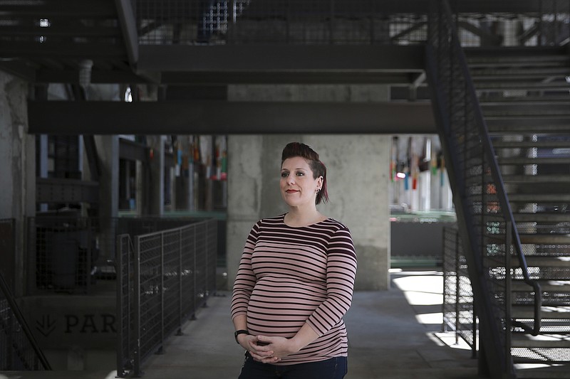 In this March. 6, 2019, photo Valarie Regas poses for a photo at Ponce City Market in Atlanta. Child care costs delayed Regas' return to the job market after she gave birth to her second child in 2012. Regas wanted to go back, but most of the jobs she found didn’t pay enough to cover child care. So, she remained mostly out of the job market for five more years. After completing a coding boot camp, Regas was hired last year by a division of the European aerospace giant Airbus. (AP Photo/Elijah Nouvelage)