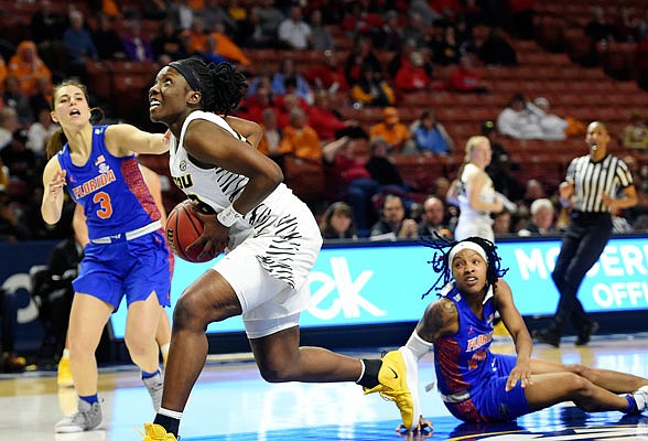 Missouri's Amber Smith drives to the basket past Florida's Funda Nakkasoglu (left) and Delicia Washington during the second half of Thursday afternoon's SEC Tournament game in Greenville, S.C.