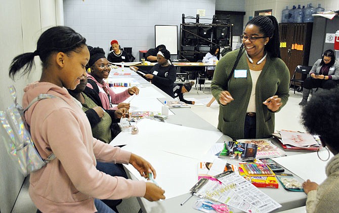 Callie Newsom, right, Girls Empowerment Zone founder and director chats with mentee and seventh-grader Saniazaja Gray on Tuesday while the girls work on their vision board at Lewis and Clark Middle School. 