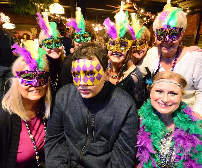 Jacob Gladbach, surrounded by family and friends, enjoys a Mardi Gras-themed fundraiser Saturday at Bones Restaurant and Lounge. He recently went through a bone marrow transplant and looks forward to the day he can go back to school.