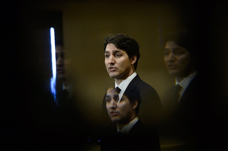 FILE - In this March 8, 2019, file photo, Prime Minister Justin Trudeau is seen through a beveled pane of glass in a door as he takes part in a news conference in Iqaluit, Nunavut, Canada. Nothing illegal is being alleged, but the no money, no sex scandal engulfing Trudeau could topple him in the election this fall. The ex-justice minister and attorney general says Trudeau and senior members of his government inappropriately tried to pressure her to instruct prosecutors to avoid criminal prosecution of a major Canadian engineering company. (Sean Kilpatrick/The Canadian Press via AP, File)