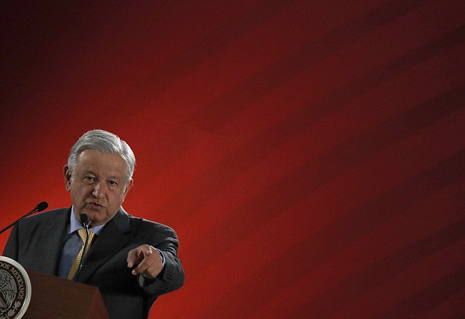 In this March 8, 2019 photo, Mexican President Andres Manuel Lopez Obrador takes questions from journalist at his daily 7 a.m. press conference at the National Palace in Mexico City. Lopez Obrador's first 100 days in office have combined a compulsive shedding of presidential trappings with a dizzying array of policy initiatives, and a series of missteps haven't even dented his soaring approval ratings.(AP Photo/Marco Ugarte)
