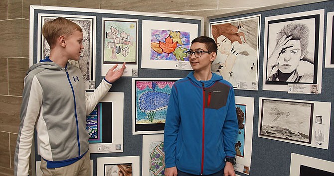 Ron Blocklage, left, and John Lombardi stand next to their artwork on display Monday in the third floor Capitol Rotunda. They are among four students from Russellville Middle School who were among those recognized during the annual Youth Art Month Capitol Exhibit. The event is sponsored by the Missouri Art Education Association and concluded Youth Art Month.