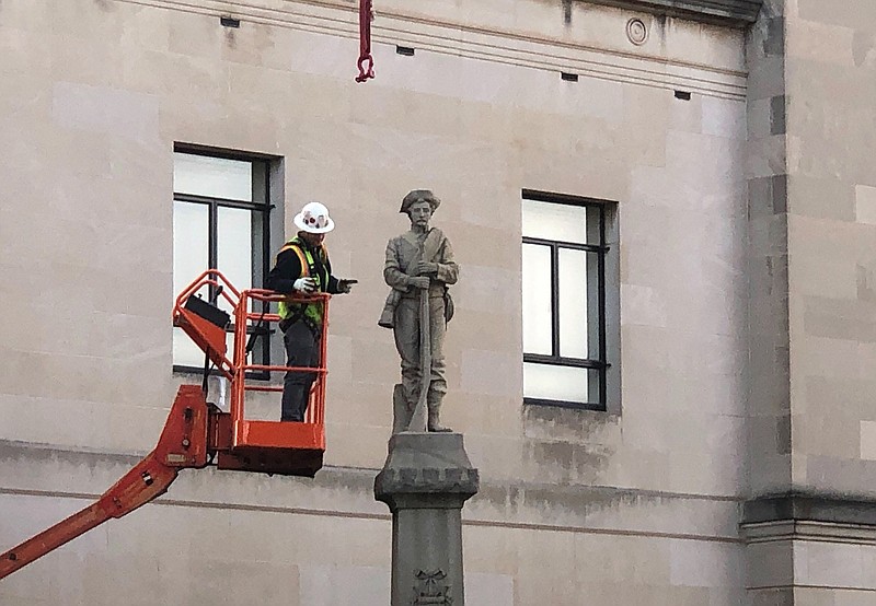 A workman prepares a Confederate staute for removal, Tuesday, March 12, 2019, in Winston-Salem, N.C. Crews began removing the Confederate statue Sunday from the grounds of an old courthouse. North Carolina has been at the forefront of the debate over what to do with Confederate monuments as one of three southern states with the most statues, according to the Southern Poverty Law Center. (AP Photo/Tom Foreman Jr.)