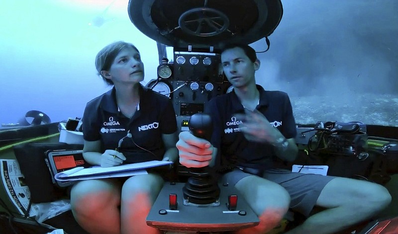 An image taken from video issued by Nekton shows Lucy Woodall, Nekton Mission principle scientist, left, alongside pilot Randy Holt inside a submersible 60 metres below surface of Indian Ocean during a descent into the Indian Ocean off Alphonse Atoll near the Seychelles, Tuesday March 12, 2019. Members of the British-led Nekton research team boarded two submersible vessels and descended into the waters off the Seychelles on Tuesday, marking a defining moment in their mission to document changes to the Indian Ocean. The submersibles will be battling strong undersea currents and potentially challenging weather conditions as they survey the side of an undersea mountain off Alphonse Atoll. (Nekton via AP)