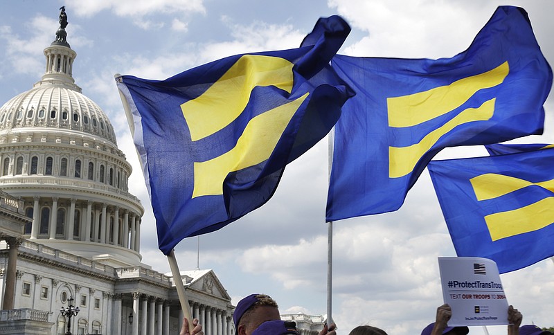 FILE - In this Wednesday, July 26, 2017 file photo, people with the Human Rights Campaign hold up "equality flags" during an event organized by Rep. Joe Kennedy, D-Mass., in support of transgender members of the military on Capitol Hill in Washington, after President Donald Trump said he wants transgender people barred from serving in the U.S. military. Congress will soon consider a comprehensive LGBT nondiscrimination bill, but it could well be doomed by lack of Republican support. (AP Photo/Jacquelyn Martin)