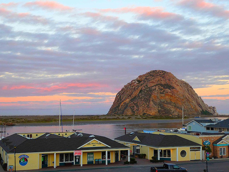 Morro Rock stands silhouetted against the reflected colors of the dawn sky. (Patricia Harris/TNS)