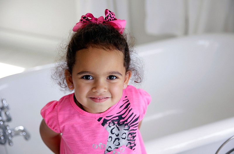 In this Aug. 6, 2013, file photo, Veronica, 3, a child at the center of an international adoption dispute at the time, smiles in a bathroom of the Cherokee Nation Jack Brown Center in Tahlequah, Okla. A federal law that gives preference to Native American families in child welfare proceedings involving Native children is facing a significant legal challenge. In 2013, the U.S. Supreme Court ruled the law didn't apply in a South Carolina case involving Veronica because her Cherokee father was absent from part of her life. (Mike Simons/Tulsa World via AP, File)