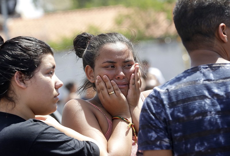 A student cries outside the Raul Brasil State School in Suzano, the greater Sao Paulo area, Brazil, Wednesday, March 13, 2019. The state government of Sao Paulo said two teenagers, armed with guns and wearing hoods, entered the school and began shooting at students. They then killed themselves, according to the statement. (AP Photo/Andre Penner)