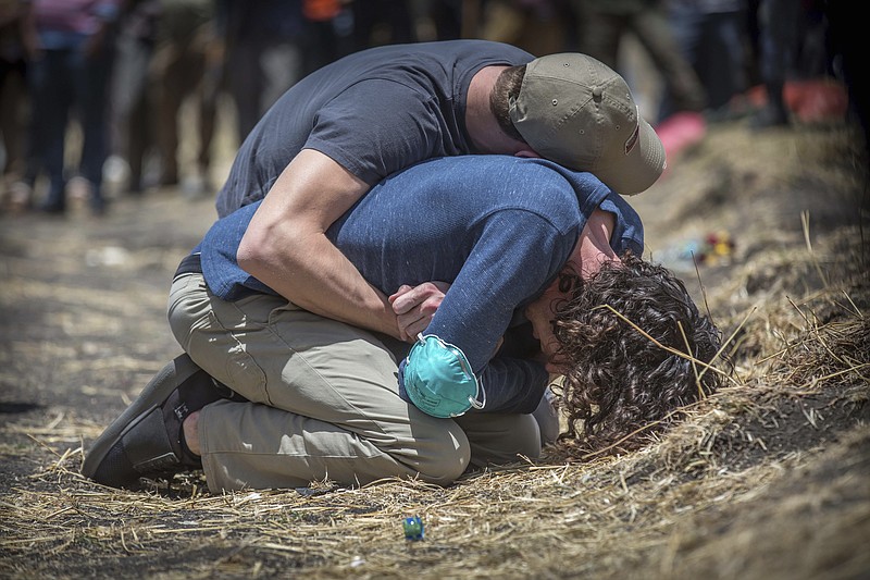 Relatives react at the scene where the Ethiopian Airlines Boeing 737 Max 8 crashed shortly after takeoff on Sunday killing all 157 on board, near Bishoftu, south of Addis Ababa, in Ethiopia Wednesday, March 13, 2019.  The black box from the Boeing jet that crashed will be sent overseas for analysis but no country has been chosen yet, an Ethiopian Airlines spokesman said Wednesday, as much of the world grounded or barred the plane model and grieving families arrived at the disaster site. (AP Photo/Mulugeta Ayene)