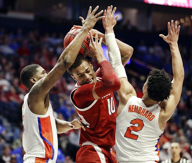 Arkansas forward Daniel Gafford (10) is trapped between Florida defenders Kevarrius Hayes, left, and Andrew Nembhard (2) in the first half of an NCAA college basketball game at the Southeastern Conference tournament Thursday, March 14, 2019, in Nashville, Tenn.