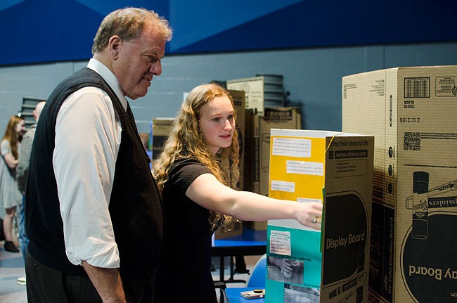 Kyle Shumate, right, explains her project to Superintendent Kevin Hillman on Wednesday during the South Callaway High School Science Fair. Shumate's experiment involved wrapping pieces of fruit with rubber bands to determine their durability.