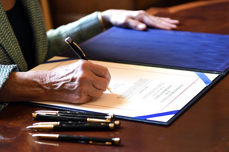 House Speaker Nancy Pelosi of Calif., signs H.J. Res 46, a disapproval resolution that blocks President Trump's National Emergency declaration, on Capitol Hill in Washington, Thursday, March 14, 2019. However, the resolution is expected to be vetoed by President Donald Trump.