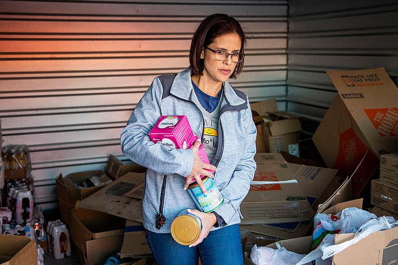 Rebecca Dominguez holds baby formula as she puts together packages at a U-Haul storage unit in Prosper, Texas, on March 6, 2019. (Shaban Athuman/Dallas Morning News/TNS)