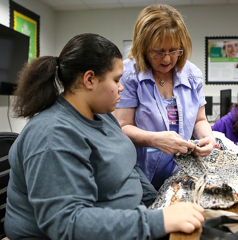 Lisa McCormack shows a student how to crochet a mat with yarn created from plastic bags on Wednesday at Ashdown High School in Ashdown, Ark. Ashdown High School has focus group days, and each group gets to pick a project. This class decided to make plastic mats that will be donated for the homeless on March 27 to Mission Texarkana. The mats will help the homeless avoid sleeping in wet conditions.
