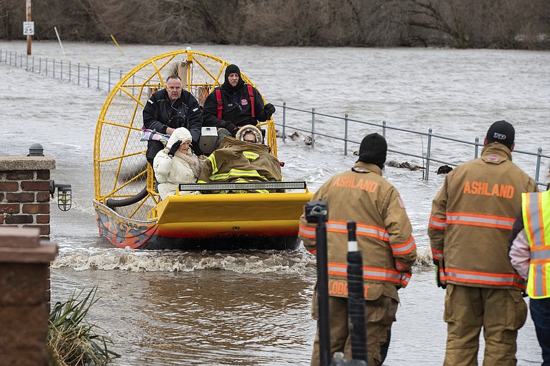 Mary Roncka and her husband Gene Roncka, right, accompanied by neighbor Kevin Mandina are evacuated as floodwaters rise Thursday, March 13, 2019, in Ashland, Neb. Evacuations forced by flooding have occurred in several eastern Nebraska communities, as western Nebraska residents struggled with blizzardlike conditions. (Brendan Sullivan/Omaha World-Herald via AP)