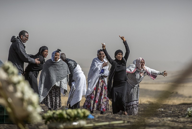 Ethiopian relatives of crash victims mourn and grieve at the scene where the Ethiopian Airlines Boeing 737 Max 8 crashed shortly after takeoff on Sunday killing all 157 on board, near Bishoftu, south-east of Addis Ababa, in Ethiopia Thursday, March 14, 2019. The French air accident investigation authority said Thursday that it will handle the analysis of the black boxes retrieved from the crash site and they have already arrived in France but gave no time frame on how long the analysis could take. (AP Photo/Mulugeta Ayene)