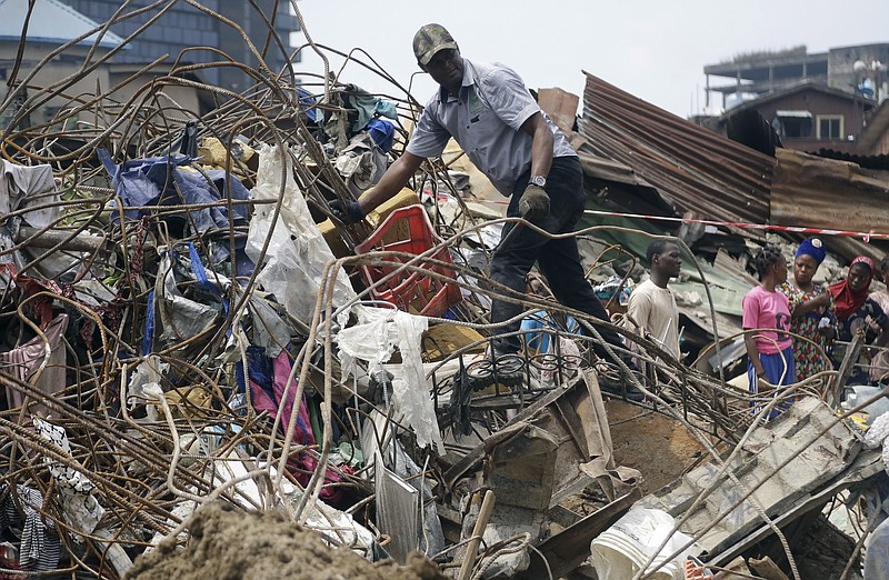 Government officials from Standard Organisation of Nigeria examine materials used in constructing the building that collapsed in Lagos, Nigeria, Thursday March 14, 2019. A Nigerian official says search efforts have been halted a day after a school building collapsed in Lagos with an unknown number of children inside.(AP Photo/Sunday Alamba
