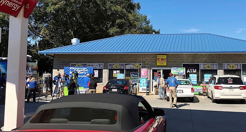 In this Oct. 24, 2018, file photo, media, at left, record people entering the KC Mart in Simpsonville, S.C., after it was announced the winning Mega Millions lottery ticket was purchased at the store. The South Carolina lottery says a single winner has stepped forward to claim the $1.5 billion Jackpot from a drawing last October. A lottery commission statement says the person submitting the claim for what was the second-largest lottery in U.S. history has chosen to remain anonymous. (AP Photo/Jeffrey Collins, File)