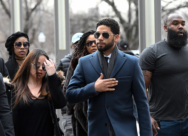 Empire actor Jussie Smollett, center, arrives at the Leighton Criminal Court Building for his hearing on Thursday, March 14, 2019, in Chicago.  Smollett is accused of lying to police about being the victim of a racist and homophobic attack by two men on Jan. 29 in downtown Chicago. (AP Photo/Matt Marton)