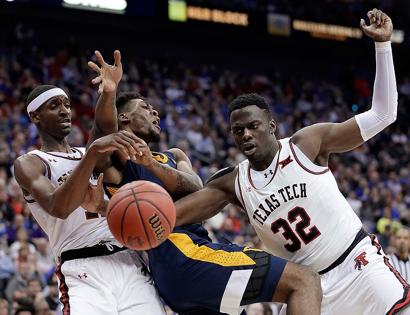 West Virginia's Derek Culver, center, battles Texas Tech's Tariq Owens, left, and Norense Odiase (32) for a loose ball during the second half of an NCAA college basketball game in the Big 12 men's tournament Thursday, March 14, 2019, in Kansas City, Mo. West Virginia won 79-74. (AP Photo/Charlie Riedel)