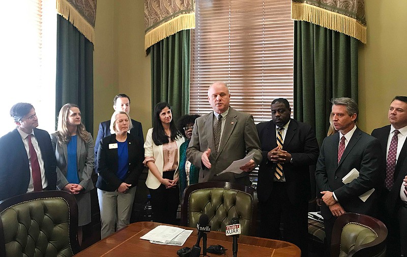 Arkansas Senate President Jim Hendren, center, speaks about a proposal to raise taxes on cigarettes and e-cigarettes to pay for tax cuts for low-and middle-income residents at the state Capitol in Little Rock, Ark., Thursday, March 14, 2019. (AP Photo/Andrew DeMillo)