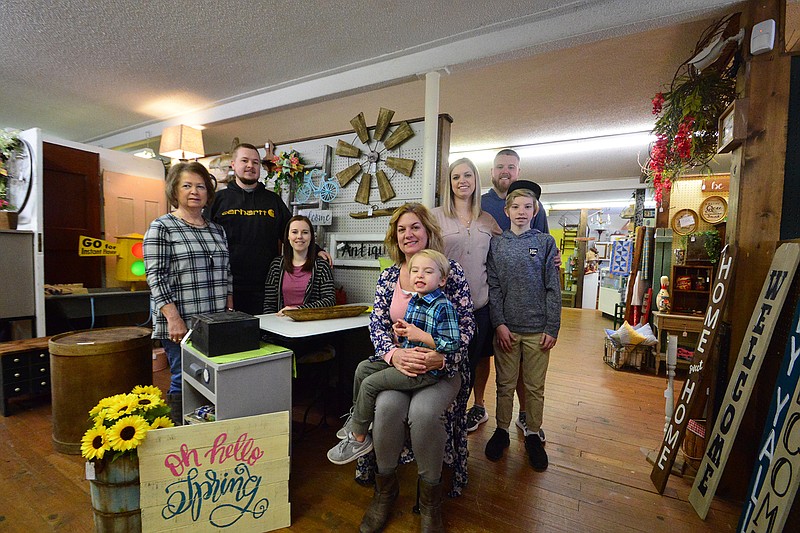 Cheri Willett with family, seated center, pose at the Missouri Boulevard Antique Mall & Dogwood Gift Company. From left to right are: Mary Beth Lechner; Tanner Morgan; Kayla Morgan; Cheri Willett and Brady Shivers, 3; Jeremy Shivers; Tiffany Shivers; and Jordan Shivers. Scott and Cheri Willett recently bought the antique mall.