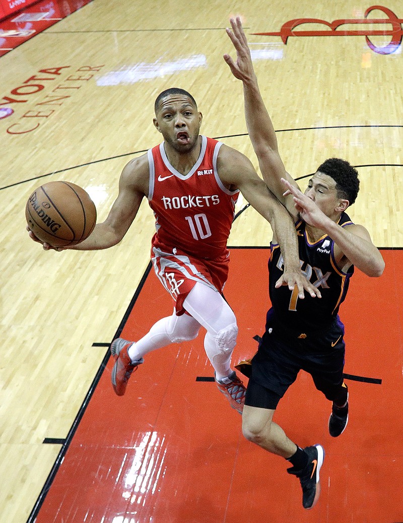 Houston Rockets' Eric Gordon (10) goes up for a shot as Phoenix Suns' Devin Booker (1) defends during the first half of an NBA basketball game Friday, March 15, 2019, in Houston. (AP Photo/David J. Phillip)