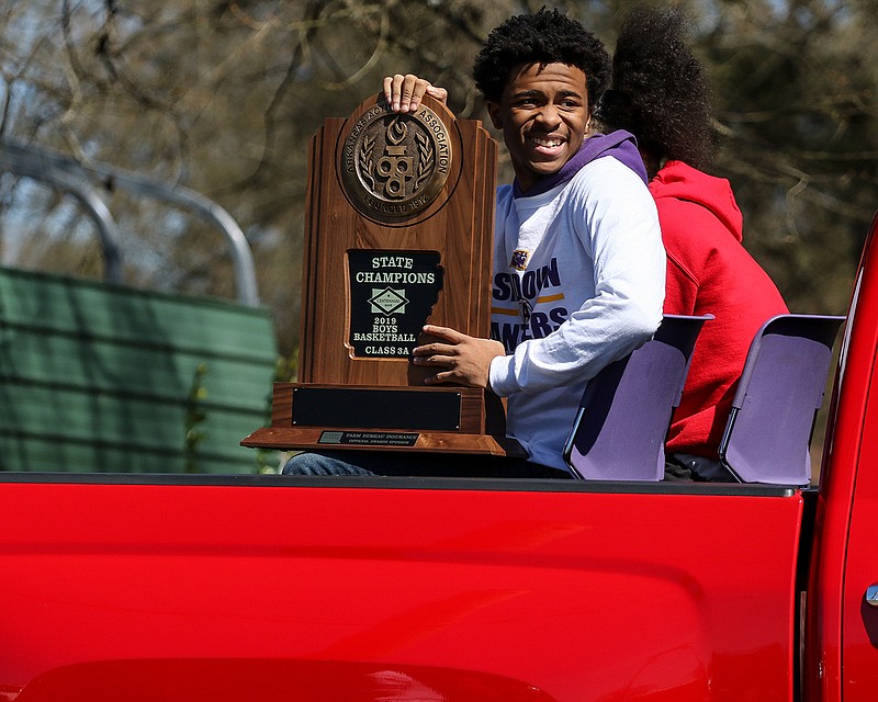 Kaiden Hunter holds the Ashdown, Ark., Panthers' 3A state championship trophy Friday during the parade to celebrate the basketball team's victory after beating Drew Central Pirates in Hot Springs.