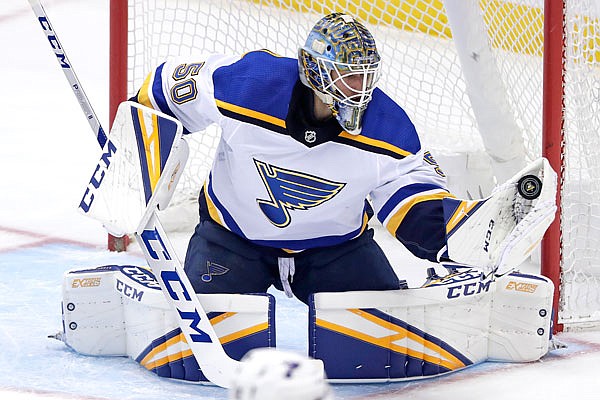 Blues goaltender Jordan Binnington gloves a shot during the first period of Saturday's game against the Penguins in Pittsburgh.