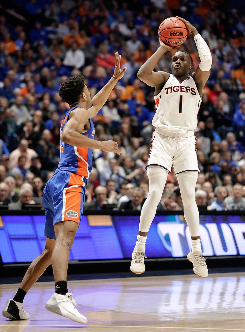 Auburn guard Jared Harper (1) makes a 3-point shot against Florida guard Jalen Hudson in the closing seconds of the second half of an NCAA college basketball game at the Southeastern Conference tournament Saturday, March 16, 2019, in Nashville, Tenn. Auburn won 65-62. (AP Photo/Mark Humphrey)