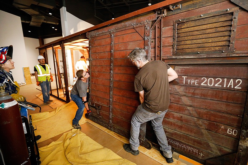 Carpenter Jeff Green, left, and lead carpenter Dennis Manske erect a door on the rail car that'll be on display at the new Dallas Holocaust and Human Rights Museum under constriction in downtown Dallas, Friday, March 8, 2019. The early 1900's German-made railroad boxcar was used during the World War but unknown what its use.  (Tom Fox/The Dallas Morning News via AP)