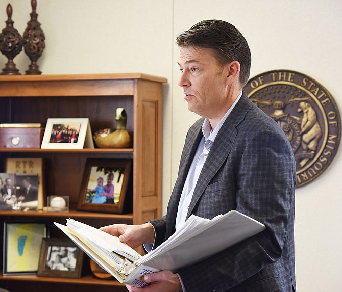 Todd Richardson, former Speaker of the Missouri House of Representatives, who is now director of MO HealthNet, points out the "2006 Medicaid Transformation" binder, which he says is a constant reminder of the task he's undertaken.