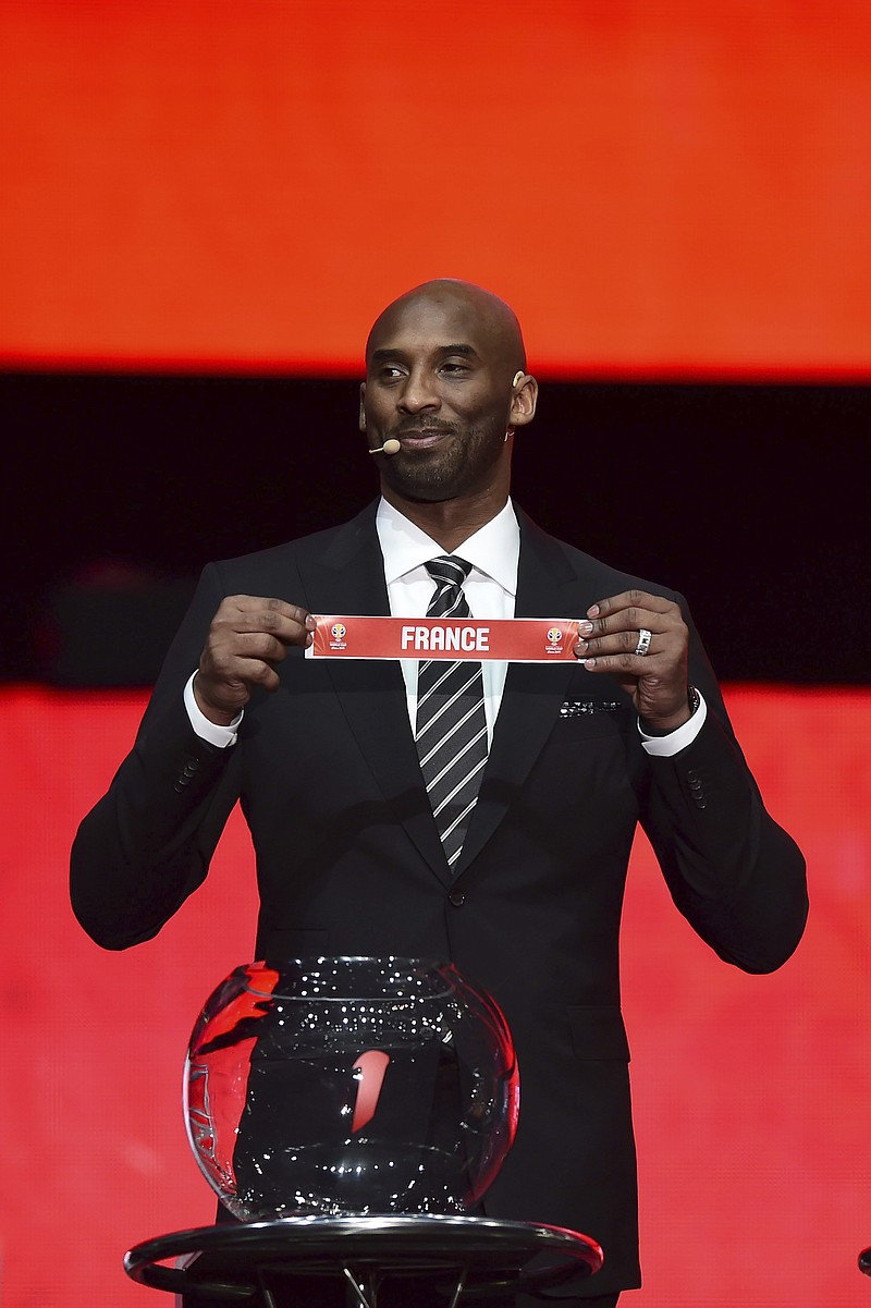 Former NBA basketball player and FIBA World Cup Ambassador Kobe Bryant holds the draw slip for France during the draw ceremony for the 2019 FIBA Basketball World Cup in Shenzhen in southern China's Guangdong Province, Saturday, March 16, 2019. The competition will take place in 8 cities across China later this year. (Chinatopix via AP)