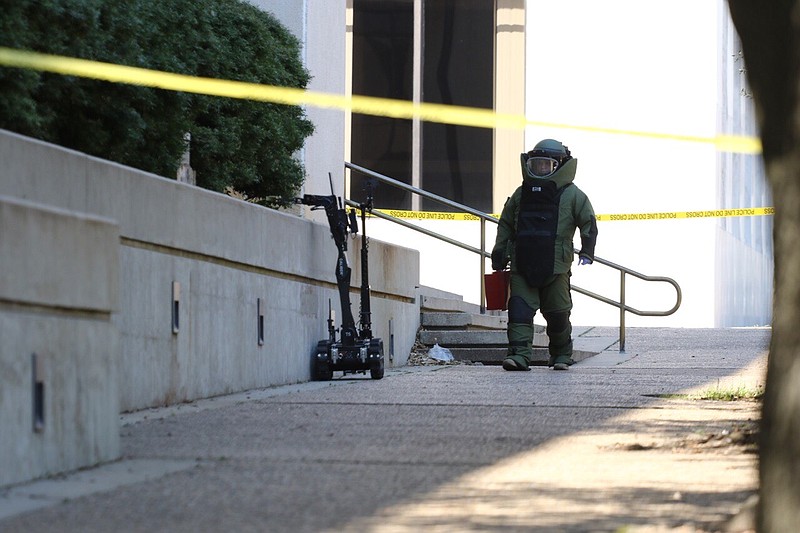 An El Dorado officer walks towards a suspicious package outside of the Bi-State Justice Building in his Explosive Ordnance Disposal suit on Monday, March 18, 2019, in Texarkana, Texas. The Bi-State Justice Building was evacuated about 9:40 a.m. today and a bomb squad is en route to investigate the report of a "suspicious package" outside of the building, an official said.