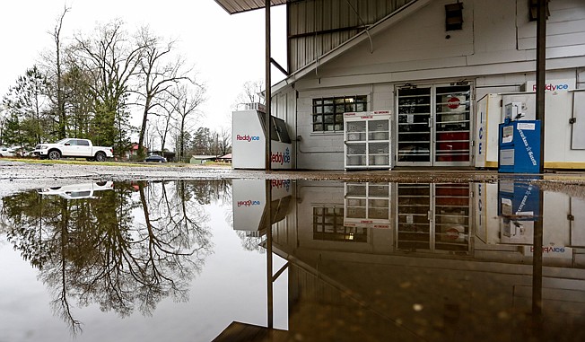 The Rock Store is reflected in a puddle of water Wednesday at the Ferguson Crossroads, 9 miles from Texarkana. The store, which had been in business since 1941, is now available for a new owner.