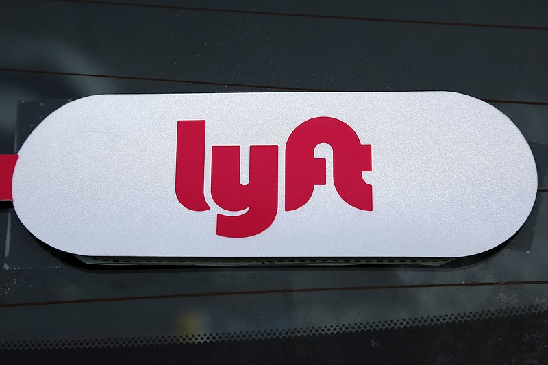 FILE - This Jan. 31, 2018 file photo shows a Lyft logo on a Lyft driver's car in Pittsburgh. Lyft officially kicked off the road show for its initial public offering Monday, March 18, 2019, with 30 million shares expected to cost between $62 and $68 per share. That would raise more than $2 billion for the San Francisco ride-hailing company, which could be valued in between $20 billion and $25 billion eventually. Lyft announced earlier this month that it intended to go public and has been in a race with Uber to be first to offer its stock to the public. (AP Photo/Gene J. Puskar, File)