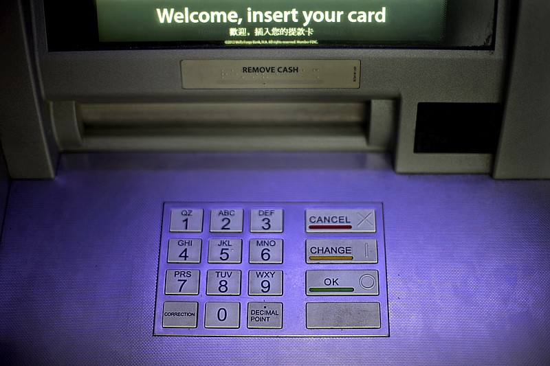 FILE - In this Tuesday, July 16, 2013, file photo, an ATM is displayed at a Wells Fargo bank, in Atlanta. Fidelity National Information Services is buying Worldpay for about $35 billion with financial transactions increasingly move online. (AP Photo/David Goldman, File)