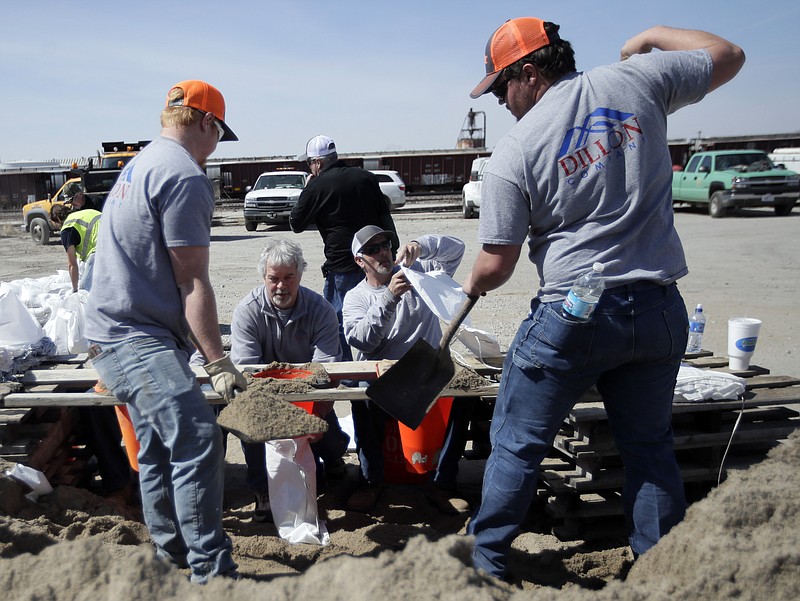 Volunteers fill sandbags in preparation for flooding along the Missouri River in St Joseph, Mo., Monday, March 18, 2019. Hundreds of homes flooded in several Midwestern states after rivers breached at least a dozen levees following heavy rain and snowmelt in the region, authorities said Monday while warning that the flooding was expected to linger. (AP Photo/Orlin Wagner)