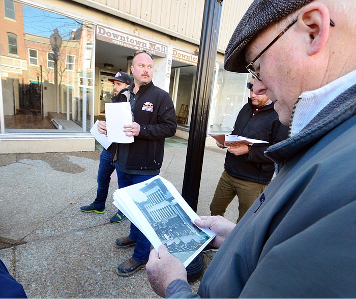 Jim Crabtree of Jefferson City's Downtown Facade Committee looks over old photographs of the Downtown Mall at 208-210 East High Street as the group, including building owners Derek Eilers and Ryan Gilmore of E & G Investments (background left and right), look over plans, improvements and changes on Feb. 26, 2019. 