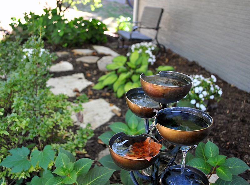 <p>(Photo by Samantha Pogue/News Tribune) While 2019 Garden of the Month recipient Heather Brown wants to add a large inground water feature in her back rocked garden, she has a water fountain feature that provides tranquil sounds in her front zen garden.</p>