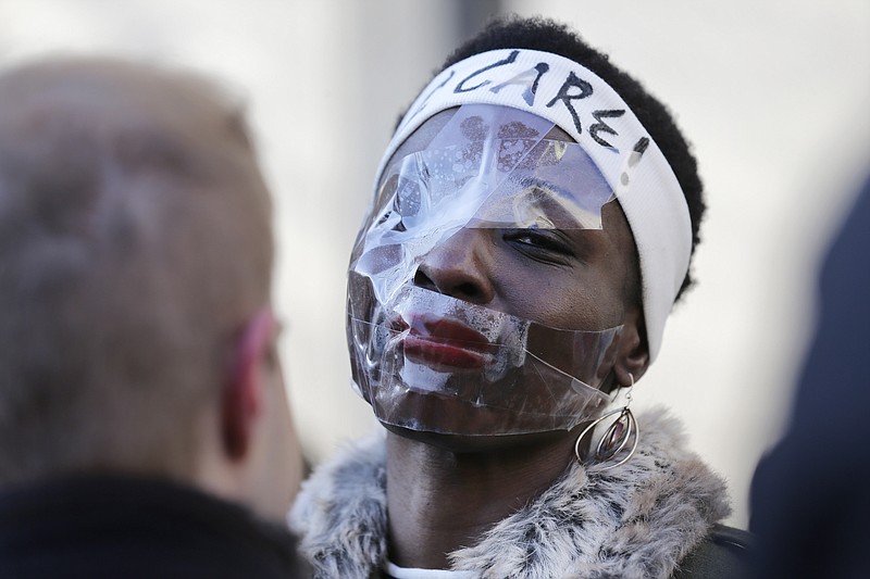 Therese Okoumou poses for pictures and rallies with supporters before her sentencing in New York, Tuesday, March 19, 2019. Okoumou was convicted of trespassing and other offenses after she climbed the base of the Statue of Liberty on July 4, 2018. (AP Photo/Seth Wenig)