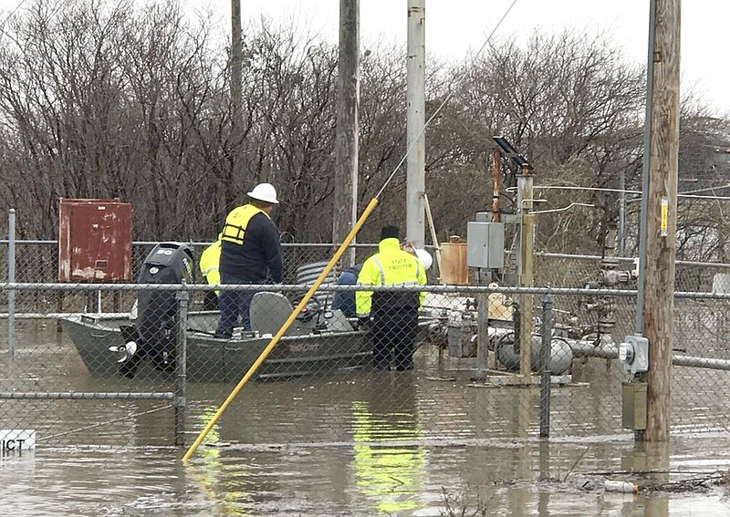 This Wednesday, March 20, 2019 photo provided by the Missouri State Highway Patrol shows Water Patrol Troopers assisting utility company employees in shutting off natural gas lines in flood waters at Craig, Mo. In northwest Missouri, a levee breached Tuesday, March 19, unleashed a torrent that overwhelmed a temporary berm that was built up with excavators and sandbags to protect the small town of Craig, where the 220 residents were ordered to evacuate. "They've got water running down Main Street," said Tom Bullock, emergency management director of Holt County, where Craig is located.