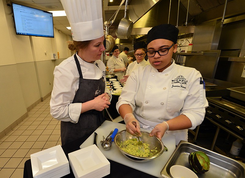 Mark Wilson/News Tribune 
Chef Amber Moore helps Jasmine Howard make guacamole during a reception Tuesday at the Nichols Career Center in the culinary kitchen.